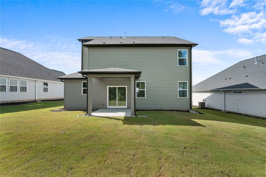 A spacious grassy lawn stretches behind this moder