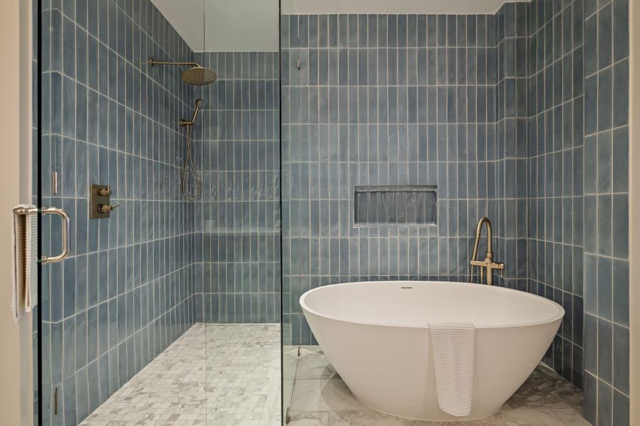 Indulge in a tranquil bathing experience with a freestanding soaking tub and a spacious glass-enclosed shower.