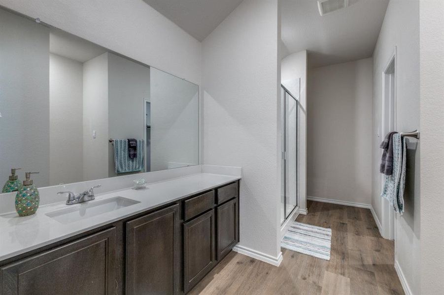Full bath with a stall shower, light wood-style flooring, and vanity Full bath with a stall shower, light wood-style flooring, and vanity