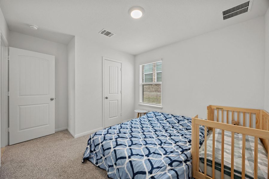 Bedroom with light colored carpet and baseboards