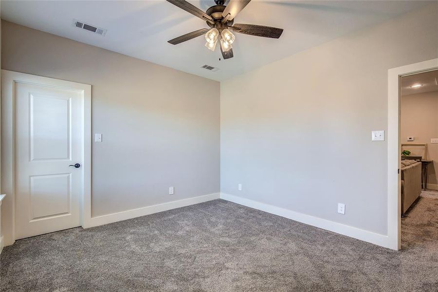 Carpeted empty room with ceiling fan