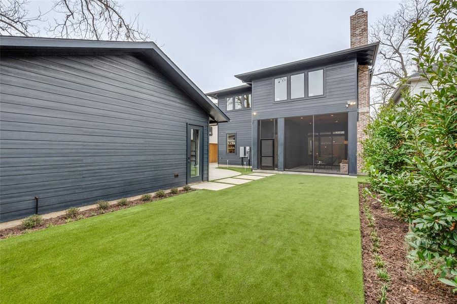 Back of house with a sunroom, a patio area, and a lawn