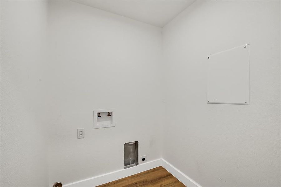 Washroom featuring hookup for an electric dryer, hookup for a washing machine, and wood-style flooring