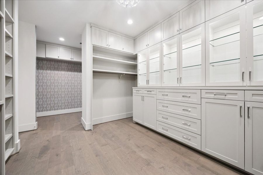 Primary closet with glass front, back lit cabinets and built in storage along with ample hanging space. Bonus area could provide additional hanging space or could double as a zen room, Peloton space or flex space was wallpapered and updated by Sellers. Primary closet with glass front, back lit cabinets and built in storage along with ample hanging space. Bonus area could provide additional hanging space or could double as a zen room, Peloton space or flex space was wallpapered and updated by Sellers.