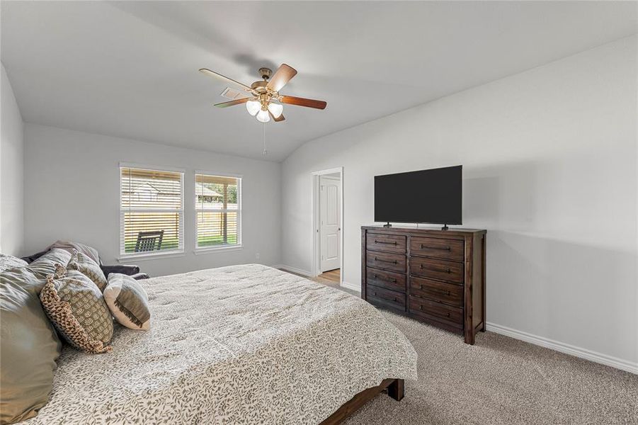 Bedroom with light carpet, lofted ceiling, and a ceiling fan