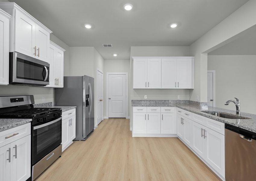 Beautiful kitchen in the Rockcress with white cabinetry, granite counters and Whirlpool brand appliances Beautiful kitchen in the Rockcress with white cabinetry, granite counters and Whirlpool brand appliances