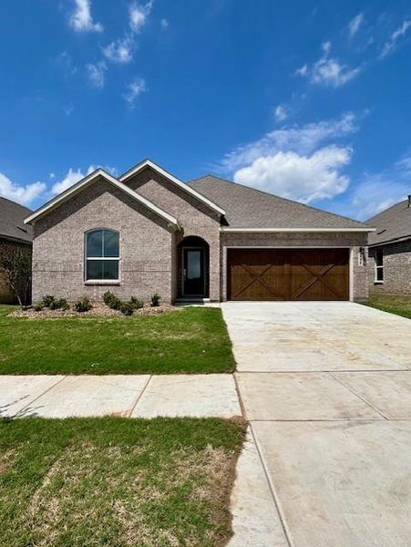 Brick exterior with an arched entry, wood-finish garage door, and an arched window Brick exterior with an arched entry, wood-finish garage door, and an arched window