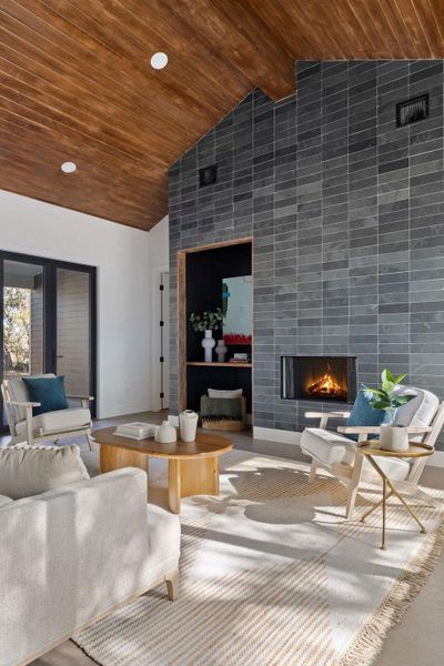 Living area featuring a wooden ceiling with exposed beams, a tile fireplace, high vaulted ceiling, and recessed lighting