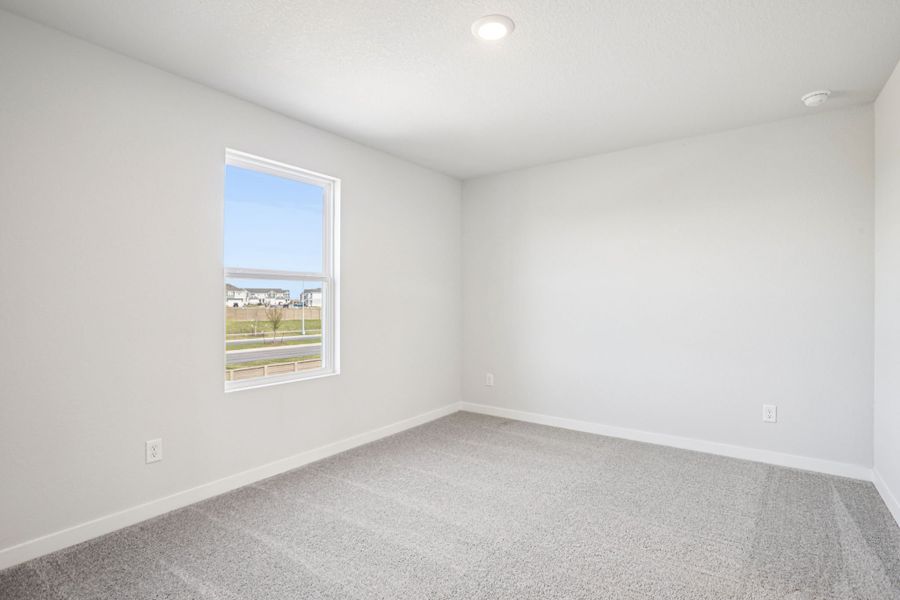 A room with a window and a white wall.