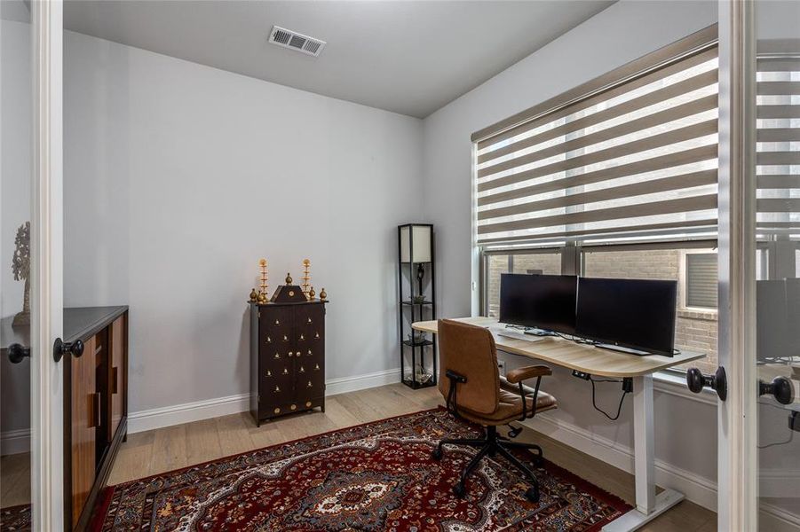 Home office featuring light wood-type flooring and baseboards
