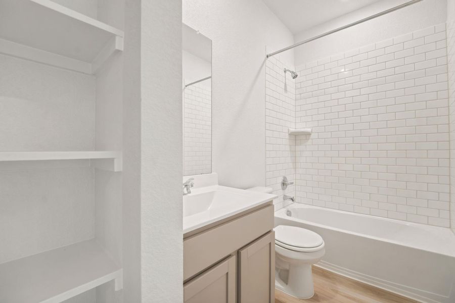 Crisp subway tile lines the shower surround in this modern guest bathroom.