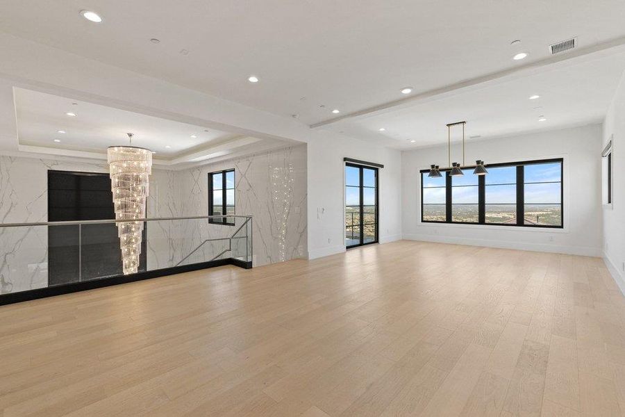 Gleaming hardwood floors and expansive windows create an airy, luminous ambiance in this refined living space.