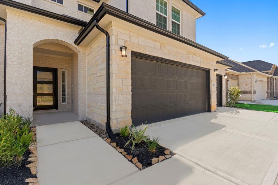 The inviting covered front entry features graceful stone accents and a charming porch that creates a warm welcome for guests. The design is both stylish and functional—perfect for a quiet morning coffee or greeting visitors with ease.