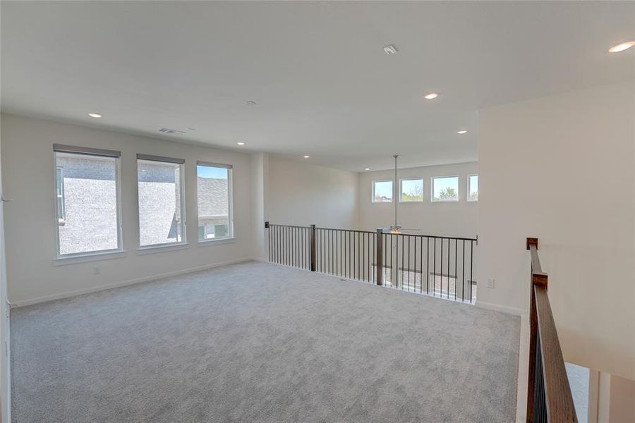Carpeted spare room with visible vents, baseboards, and recessed lighting