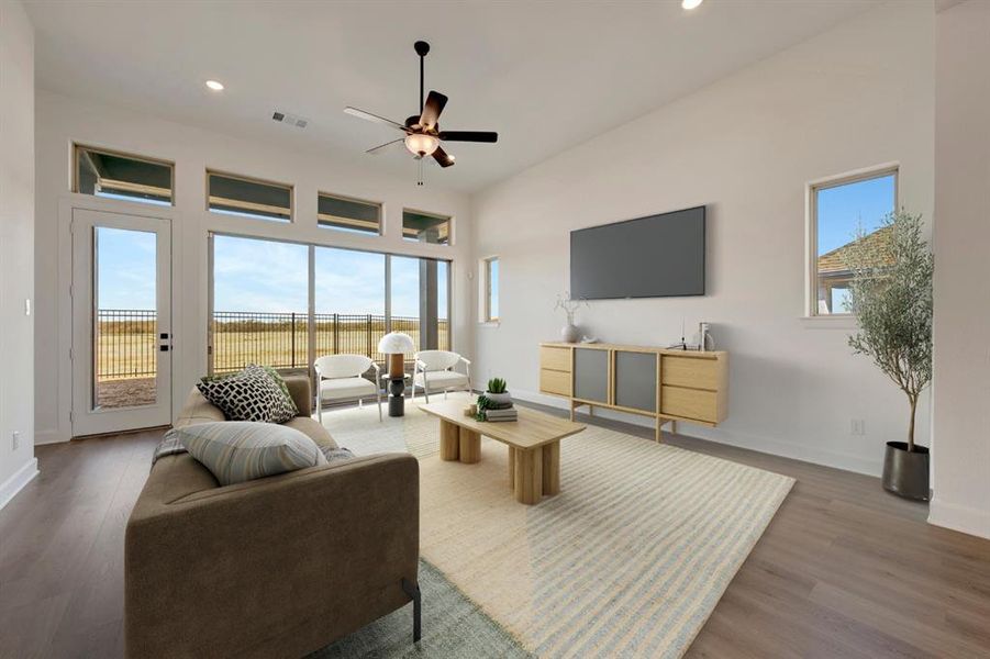 Living room with ceiling fan, wood finished floors, a high ceiling, and recessed lighting Living room with ceiling fan, wood finished floors, a high ceiling, and recessed lighting