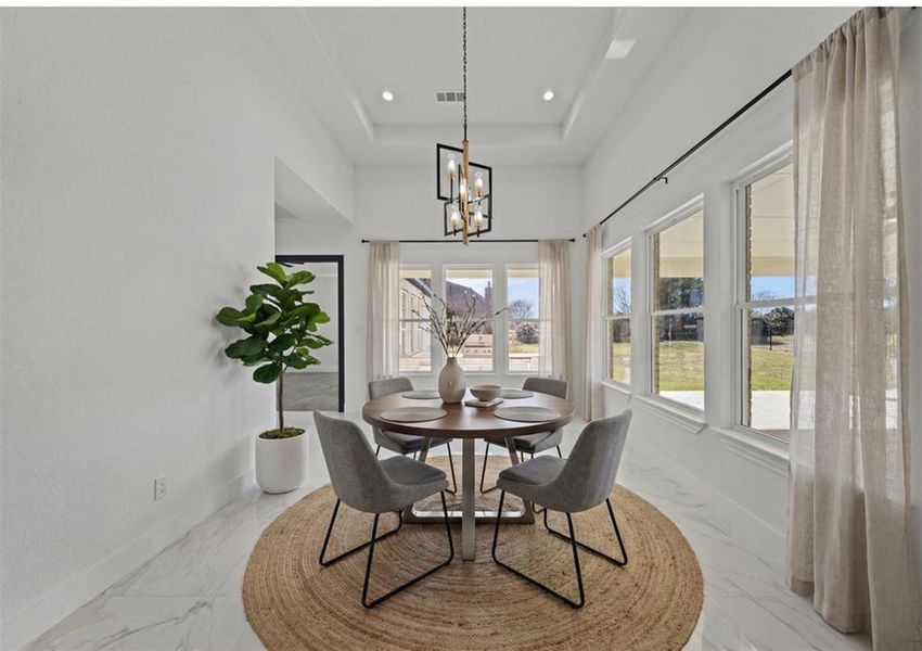 Virtually Staged - Dining space featuring a chandelier and a raised ceiling