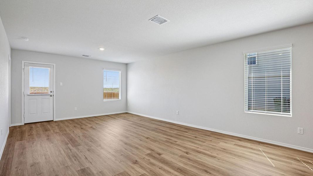 A spacious living room features resilient wood-look flooring and naturally illuminated interiors.