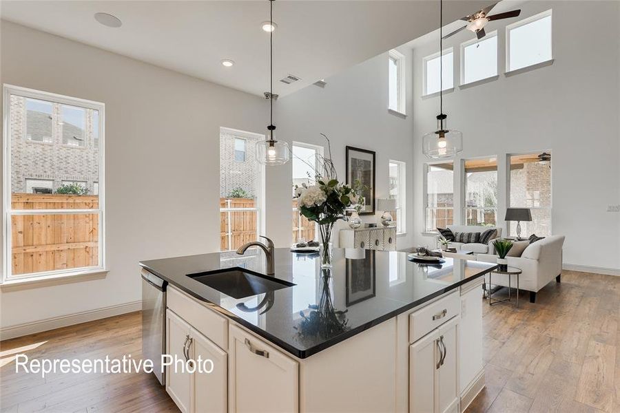 Kitchen featuring ceiling fan, plenty of natural light, sink, and a center island with sink