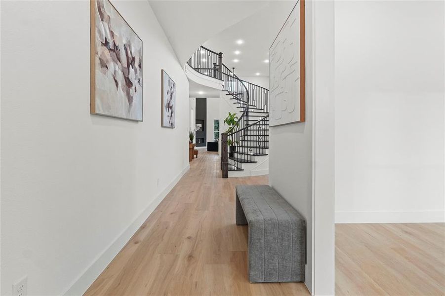 Hallway featuring light wood finished floors, recessed lighting, and stairs Hallway featuring light wood finished floors, recessed lighting, and stairs