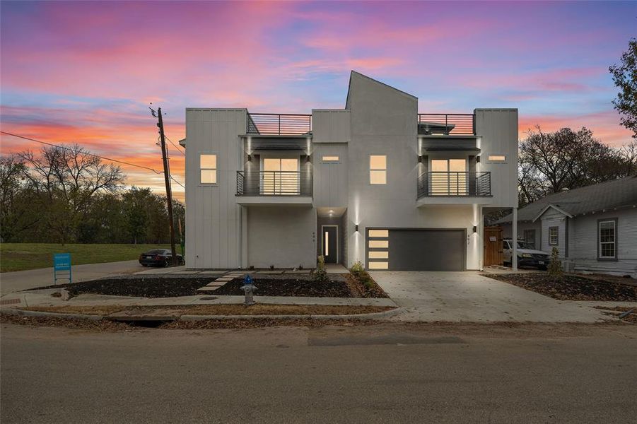 Modern home featuring a balcony, driveway, and a garage Modern home featuring a balcony, driveway, and a garage