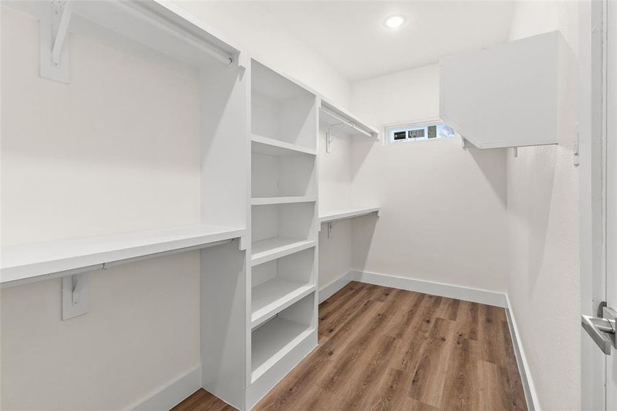 Walk in closet featuring light wood-style flooring Walk in closet featuring light wood-style flooring