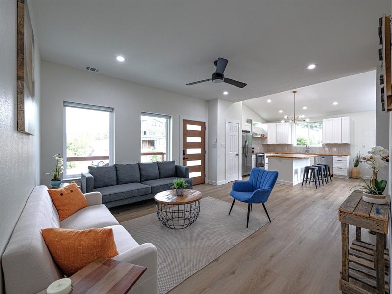 Open-concept living area featuring high ceilings, recessed lighting, and wood-finish flooring