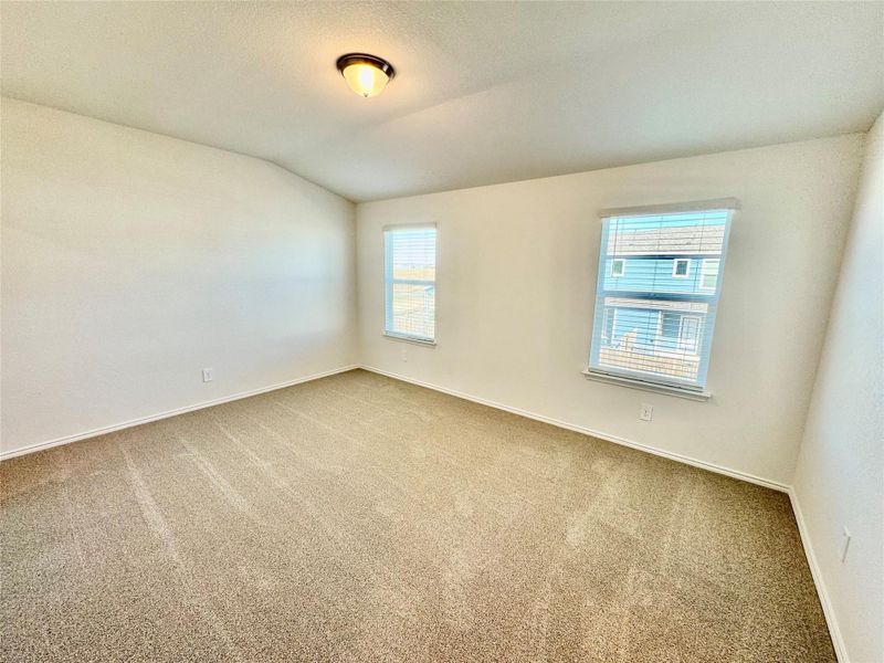 Carpeted spare room with lofted ceiling and a textured ceiling