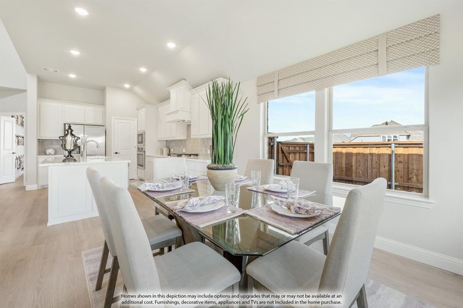 Open dining area with glass table and six chairs, connected to white kitchen with island and hardwood floors Open dining area with glass table and six chairs, connected to white kitchen with island and hardwood floors