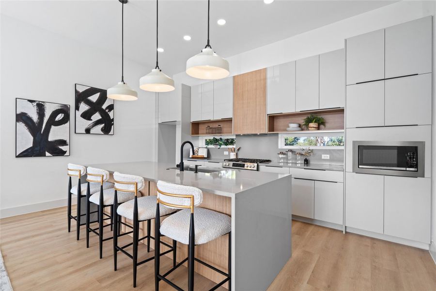 European flat-panel cabinetry, concrete-inspired quartz & a double waterfall island shape a kitchen rooted in modern craft. European flat-panel cabinetry, concrete-inspired quartz & a double waterfall island shape a kitchen rooted in modern craft.