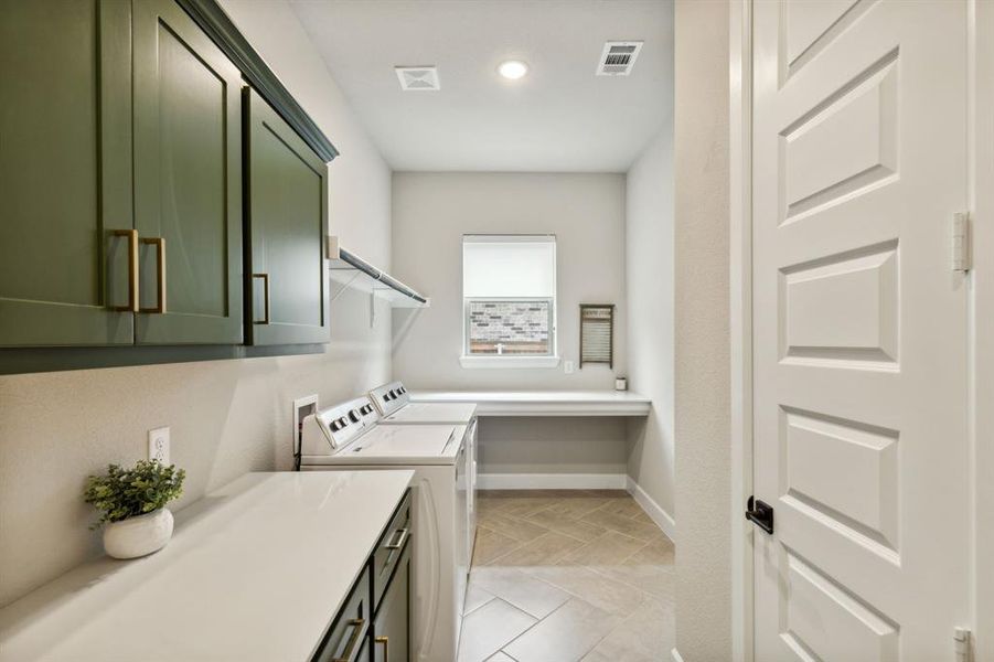 Washroom featuring washing machine and clothes dryer and cabinets