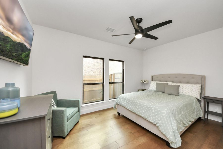 Comfortable bedroom with natural light and ceiling fan.