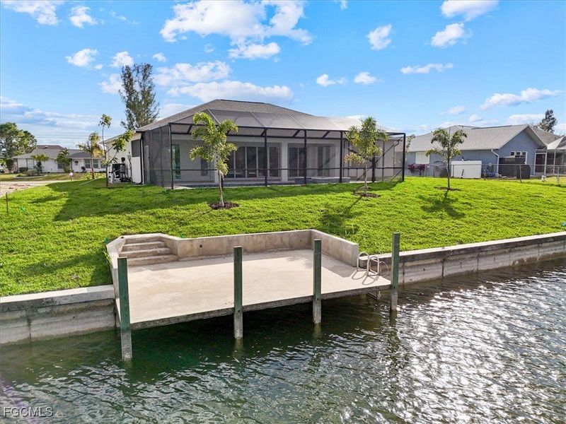 Dock area with a water view, a yard, a sunroom, a lanai, and a residential view