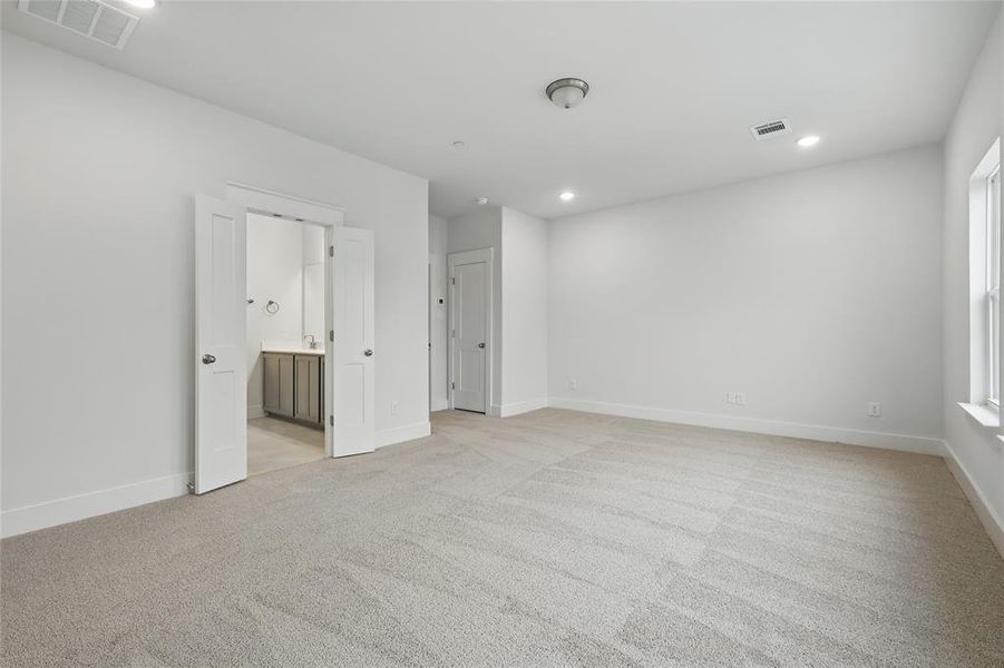 Unfurnished bedroom featuring light colored carpet, recessed lighting, and connected bathroom
