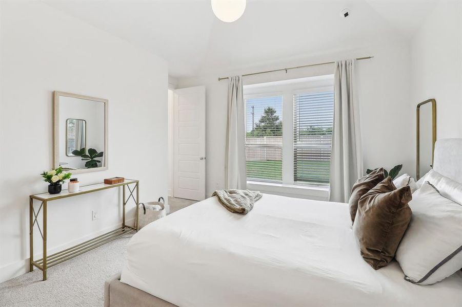 Carpeted bedroom featuring vaulted ceiling Carpeted bedroom featuring vaulted ceiling