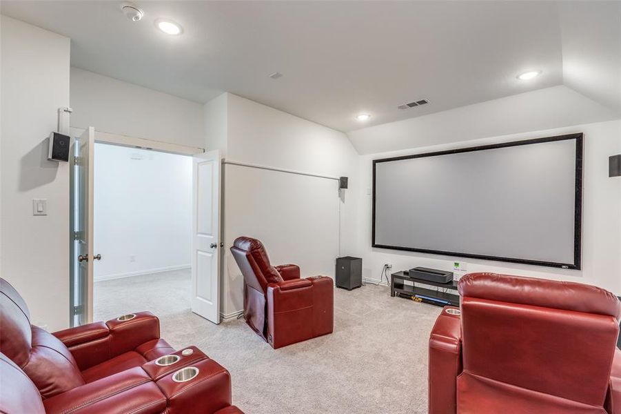 Step into your own private, carpeted home theater with French doors and a lofted ceiling. Complete with theater seating, screen, projector, speakers, and subwoofers—all conveying with the sale—this space is ready for unforgettable movie nights! Step into your own private, carpeted home theater with French doors and a lofted ceiling. Complete with theater seating, screen, projector, speakers, and subwoofers—all conveying with the sale—this space is ready for unforgettable movie nights!