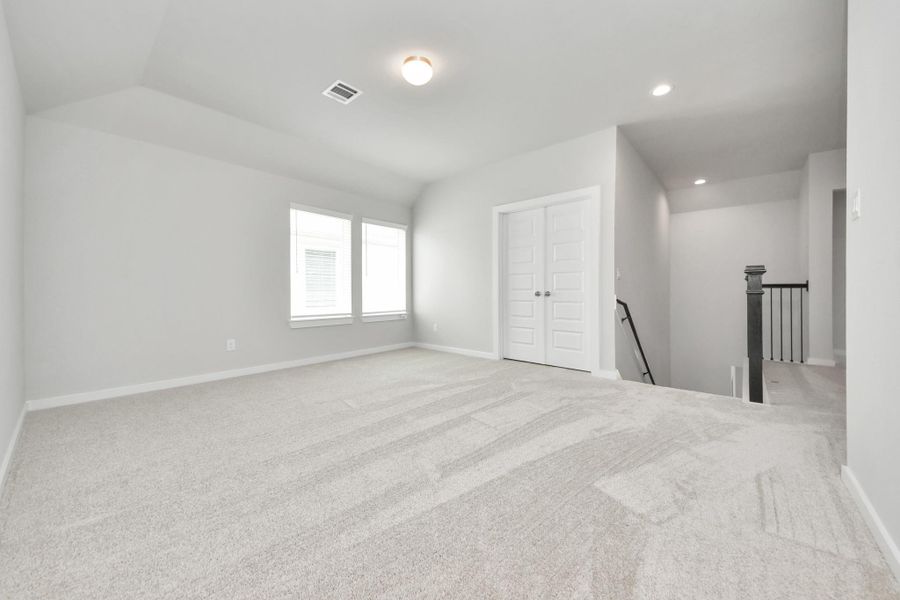 Come upstairs and enjoy a day of leisure in this fabulous game room! This is the perfect hangout spot or adult game room! Features plush carpet, high ceilings, custom paint and windows for plenty of natural light. Sample photo of completed home with similar floor plan. Actual colors and selections may vary.