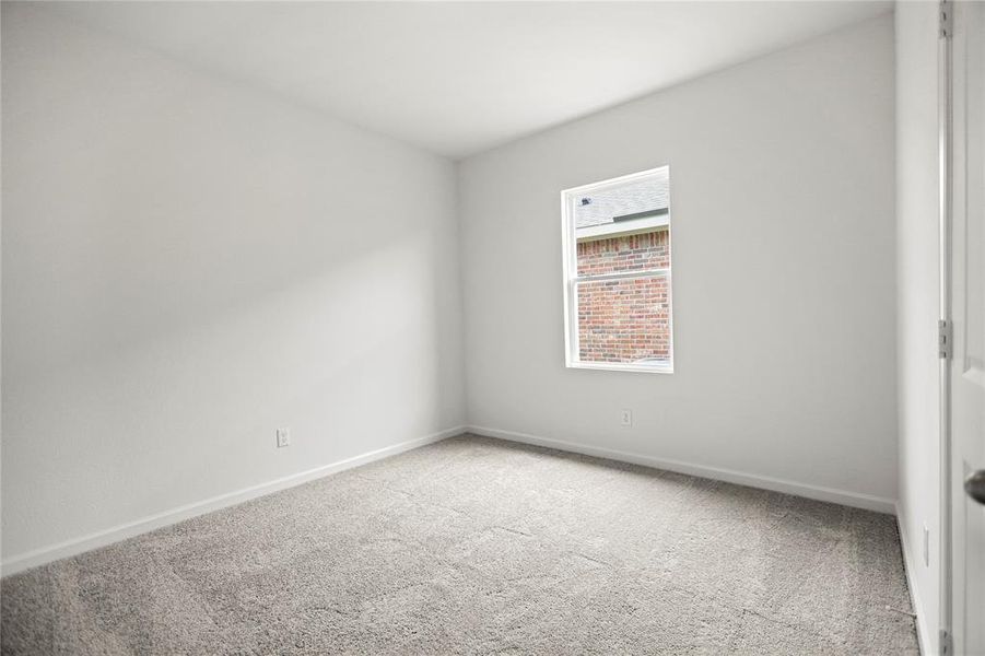 Well-proportioned secondary bedroom featuring wide wall space and soft neutral palette.