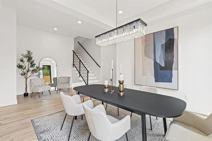 Elegant dining room with sleek chandelier, and large windows, perfect to host gatherings in a bright, inviting space.