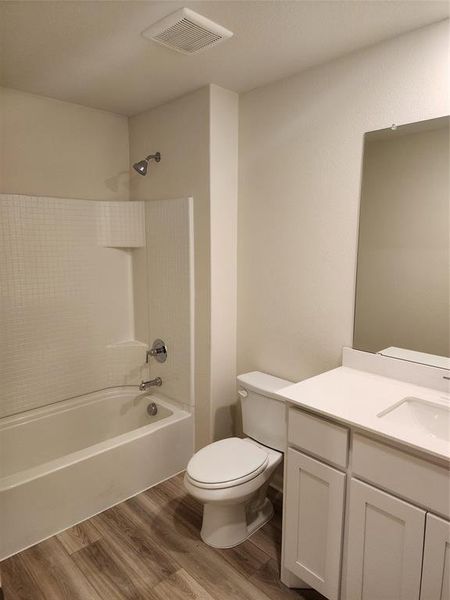 Bathroom featuring light wood finished floors, shower combination, and vanity Bathroom featuring light wood finished floors, shower combination, and vanity
