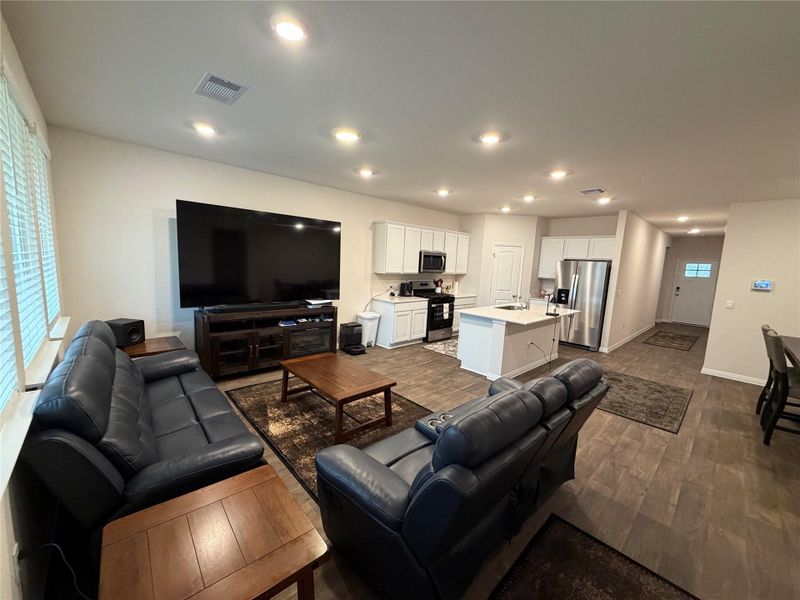 Living area with dark wood-style flooring and recessed lighting