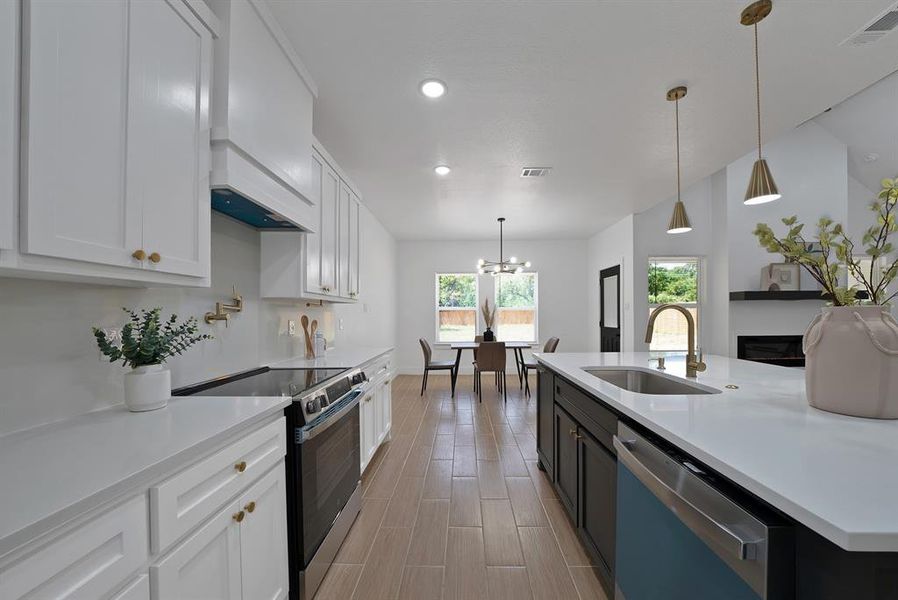 Kitchen featuring stainless steel electric stove, dishwasher, light countertops, white cabinetry, and custom range hood