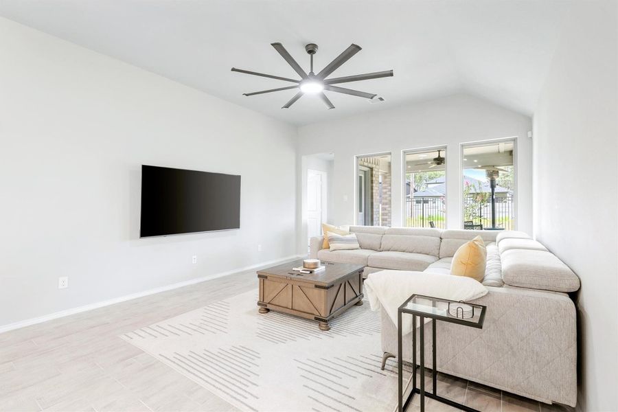 The family room features vaulted ceilings, a upgraded ceiling fan, and a wall of windows that pulls in natural light and a peek at the covered patio beyond. The family room features vaulted ceilings, a upgraded ceiling fan, and a wall of windows that pulls in natural light and a peek at the covered patio beyond.