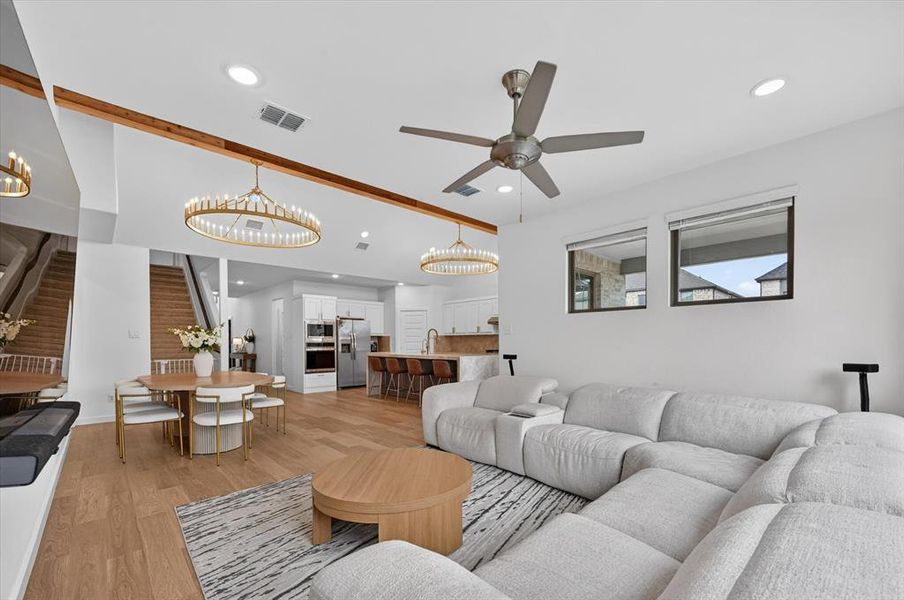 Open-concept living space with light wood-finish flooring, recessed lighting, and a ceiling fan