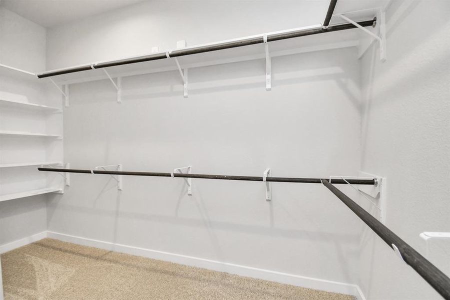 Indulge in a walk-in closet that combines luxury with practicality. This generously proportioned area includes built-in shelving, providing ample space for flawless organization. Elevated ceilings and recessed lighting contribute to a luminous and inviting atmosphere.