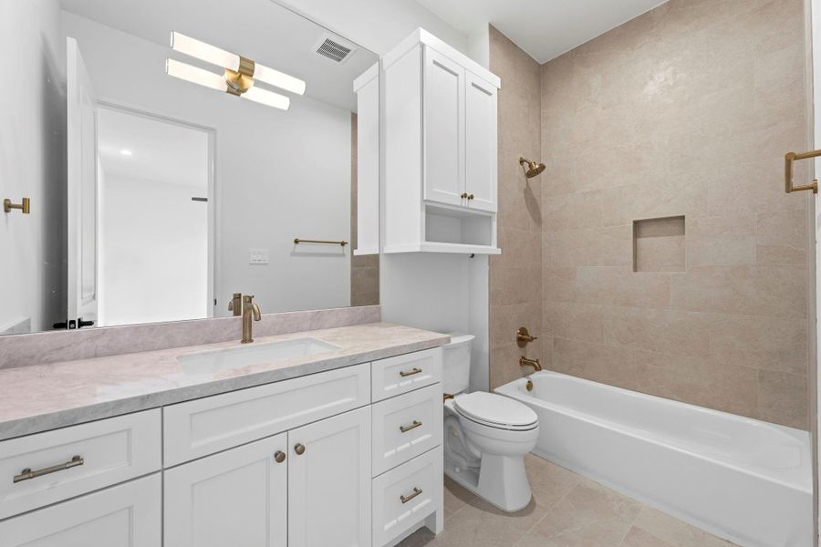 Bathroom #6 (Attached to Bedroom #5) Featuring a shower/ tub combo, WHITE cabinets, gold hardware, MODERN light fixture, and SPA- like inspired tile.