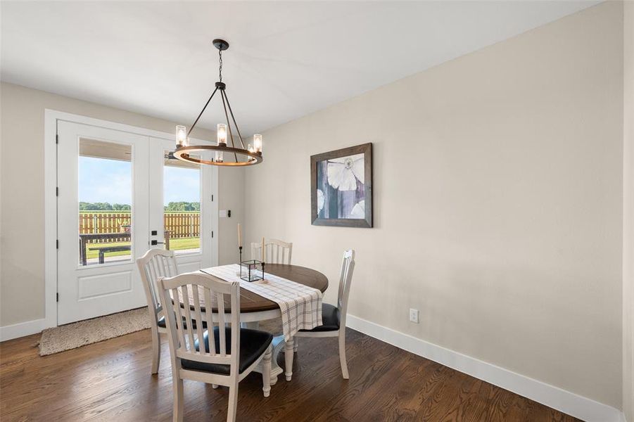 Dining room featuring a notable chandelier and dark hardwood floors