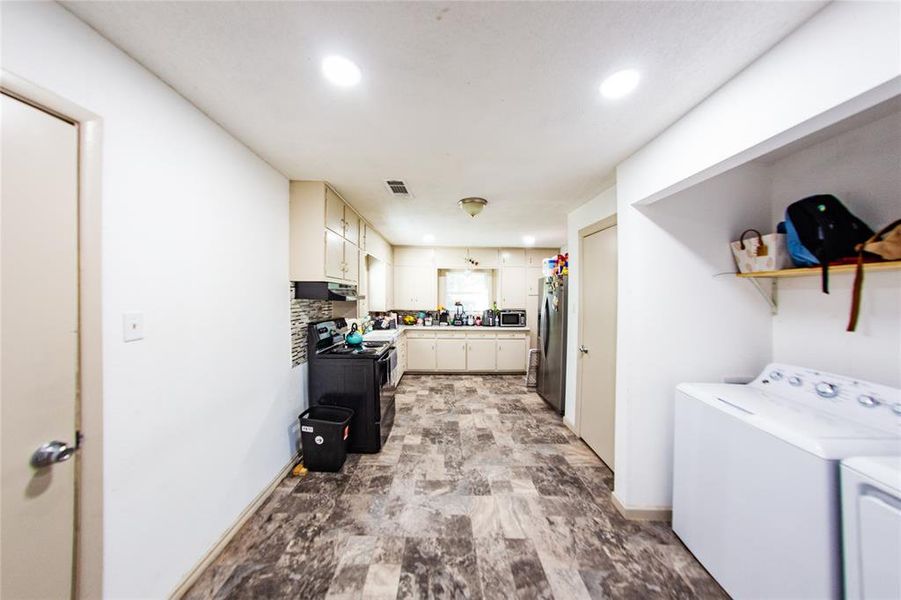 Laundry room with recessed lighting, separate washer and dryer, and stone finish flooring