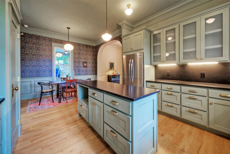 A stylish kitchen island and custom cabinetry define this inviting culinary space with ample room for dining.