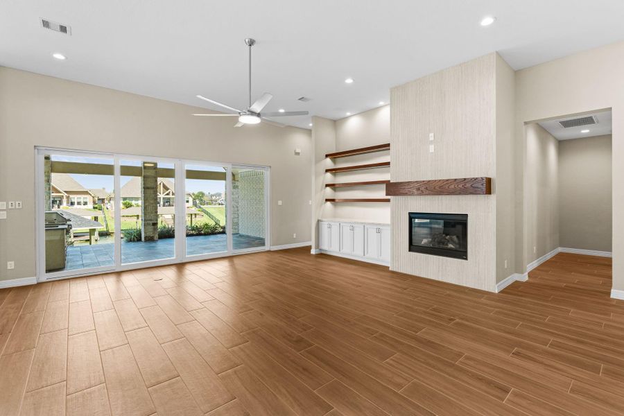 Wide view of the great room emphasizing the open layout, natural lighting, and connection to the outdoor patio.