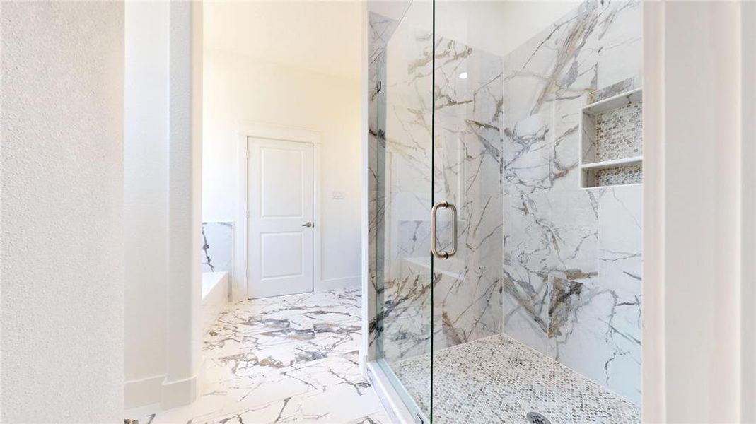 Bathroom with marble finish floor, a tub to relax in, and a marble finish shower